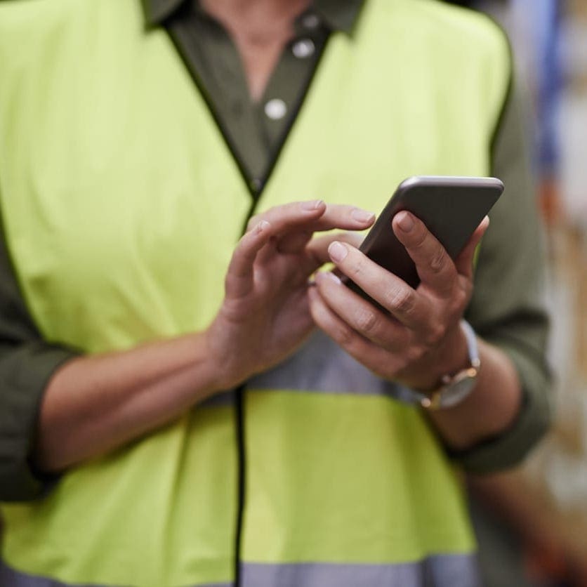 worker holding cell phone